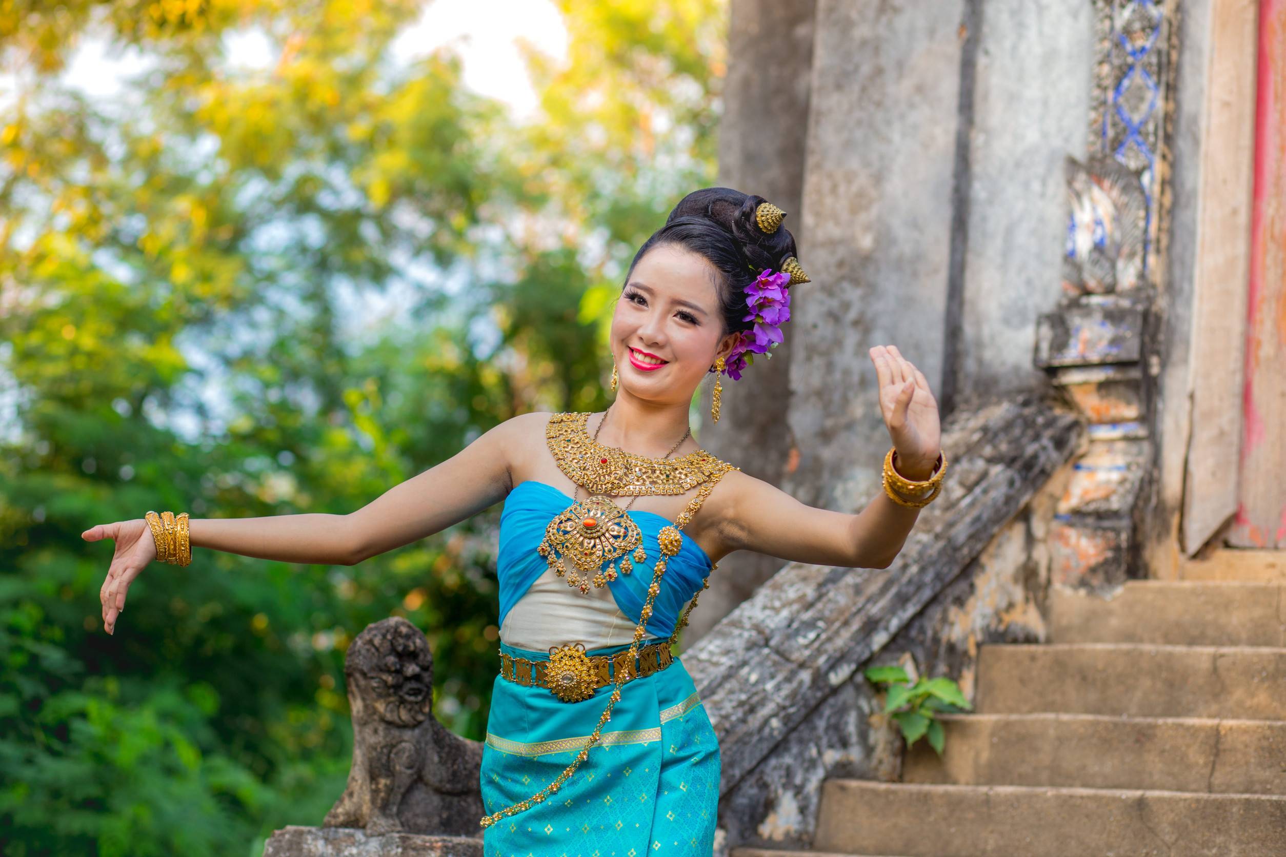 A Thai Woman Dancing In Front Of An Old Thai Temple