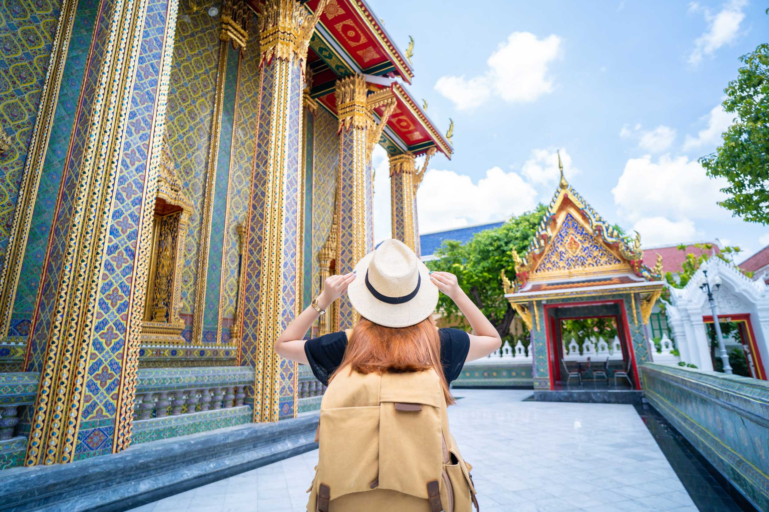 Asian Woman Carrying A Backpack Wearing A Straw Hat