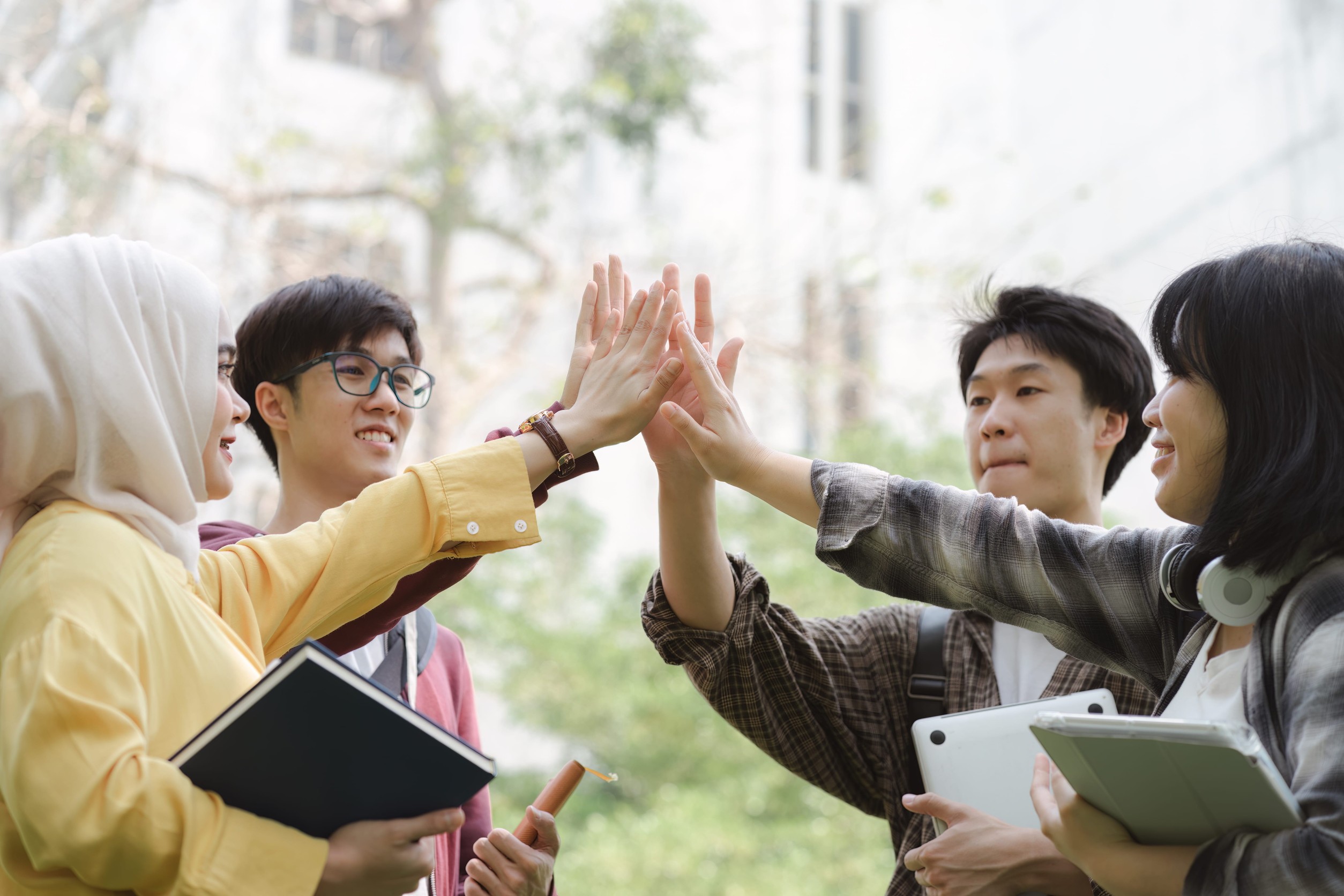Diverse Young Group Stacking Hands Showing Unity