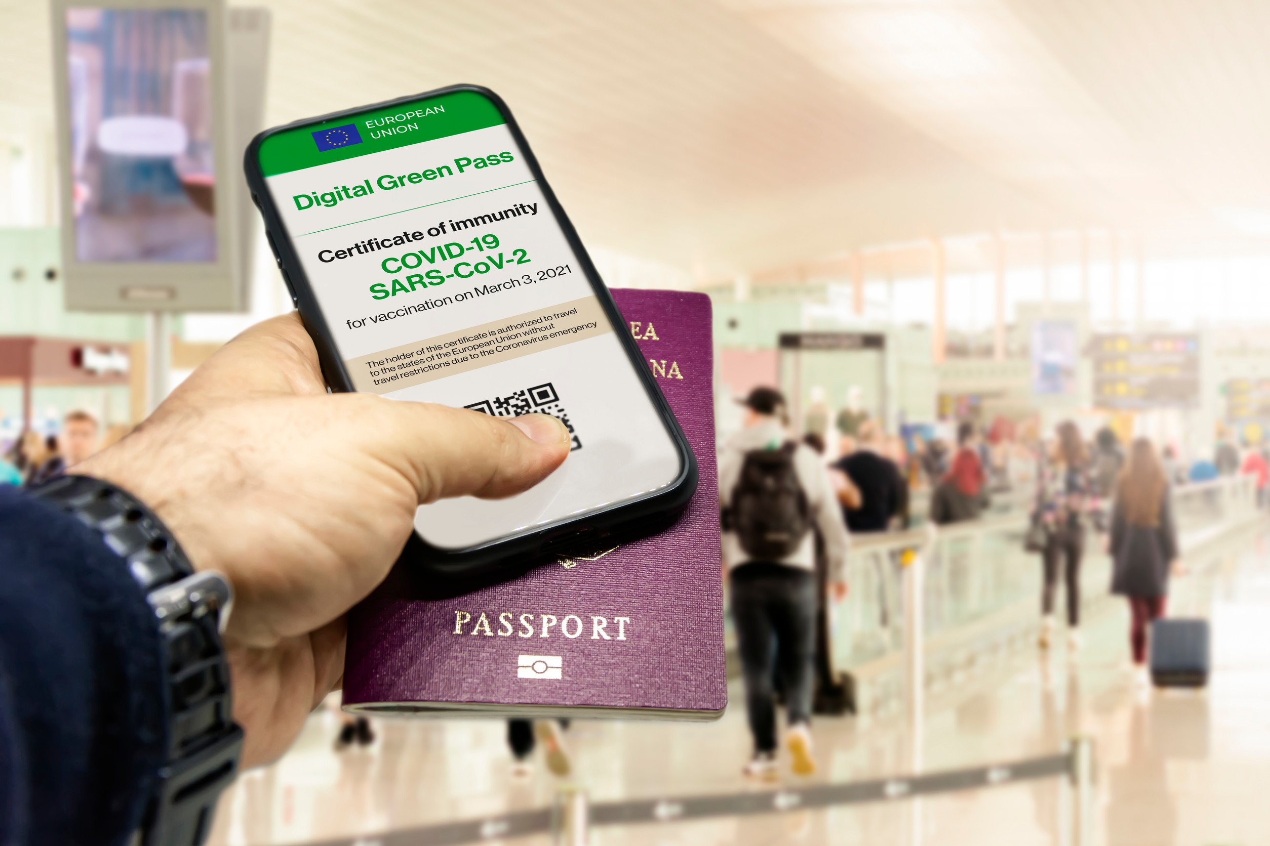 Male Hand Holding A Phone With The European Union Vaccination Certificate