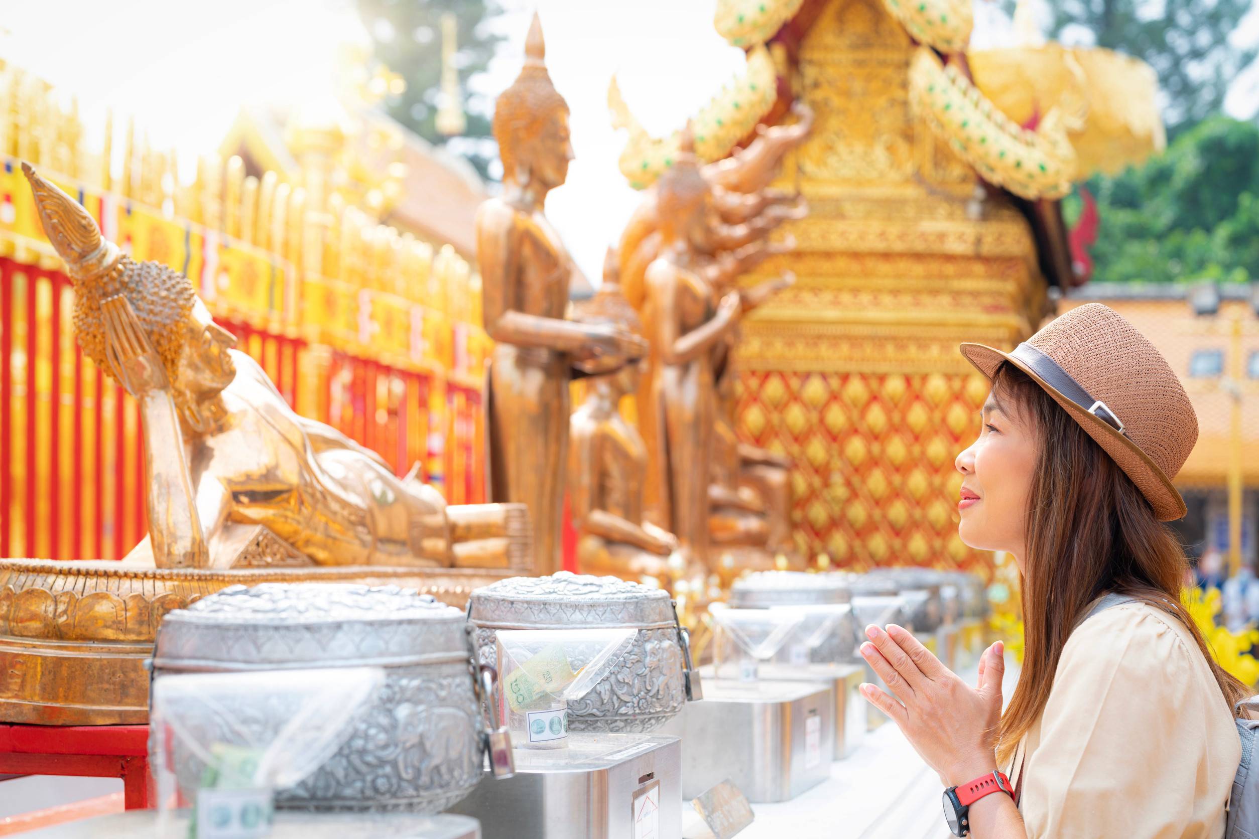 Tourist Praying In Front Of A Bronze Statue In Thailand